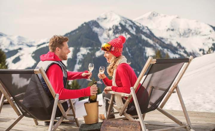 Glad par nyder drinks i solen til afterski i Obertauern